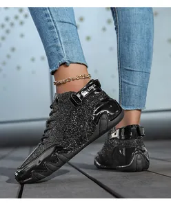 Dettaglio di sneaker alte con texture glitterata nera e accenti in pelle verniciata lucida