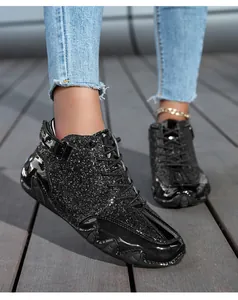 Dettaglio degli stivaletti neri con paillettes, cinturini a strappo alla moda e stringhe
