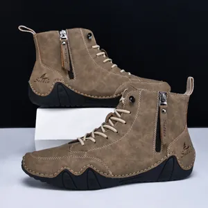 Detail von khakifarbenen Lederboots mit Reißverschluss und robuster, gezahnter Gummisohle