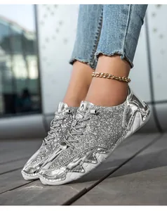 Silberner Pailletten-Sneaker mit weißer Plateausohle und metallischen Lederakzenten