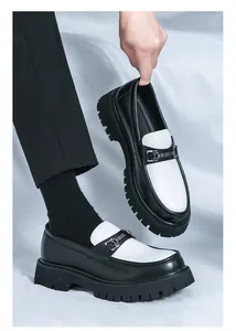 Dettaglio di mocassini in pelle bicolore con morsetto in metallo e suola platform