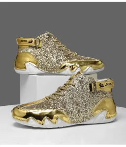 Dettaglio di sneaker alte dorate con paillettes, cinturino metallico e suola in gomma
