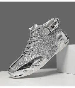 Dettaglio della superficie argento glitterata e del cinturino in velcro degli stivali