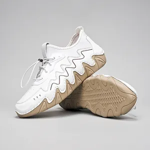 Detail of white and brown casual shoes featuring wavy serrated soles and bungee cord laces