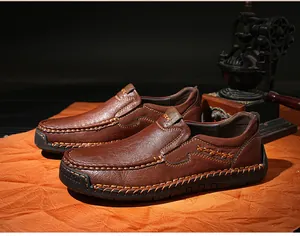 Detail of dark brown leather loafer featuring handmade stitching and rubber sole branding