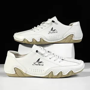 Detail of white leather men casual shoe with Salkin logo and wavy brown sole