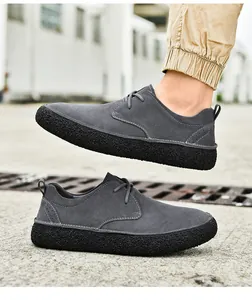 Vista laterale di scarpe casual in pelle scamosciata grigia con cuciture bianche e suola spessa