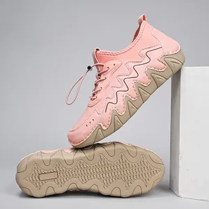 Pink women's sneakers with wavy thick soles and non-slip tread on a minimalist set