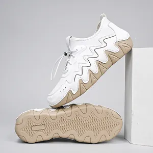 Detail view of anti-slip rubber outsole and white upper with wavy stitching on casual shoes