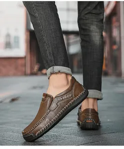 Detailed close-up of brown leather slip-on loafers with decorative white stitching