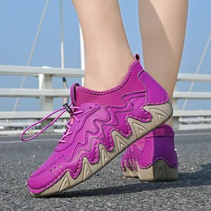 Outdoor purple hiking sneakers with thick rubber soles and bungee laces on a scenic road