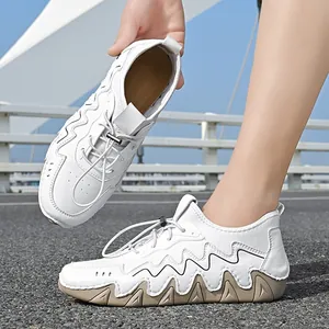 Detail of outdoor men's white sneakers with wave pattern sole and metal toggle lacing