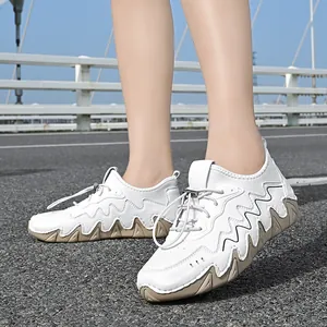 Detail of white outdoor casual sneakers with elastic laces on a sunny road