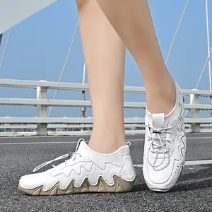 Close-up of white outdoor sneakers with wavy stitching and khaki traction rubber soles