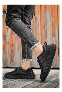 Dettaglio scarpe casual da uomo in pelle nera con cuciture a mano e spessa suola in gomma