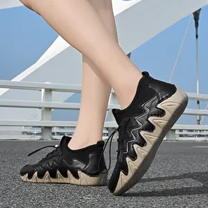 Outdoor close-up of chunky knit-leather walking shoes with non-slip sole against blue sky