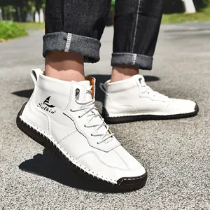 Détail de bottines hautes en cuir blanc avec logo latéral et semelle en caoutchouc cousue