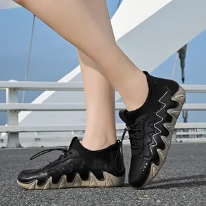 Outdoor street shot of black leather hiking shoes with thick khaki patterned rubber soles