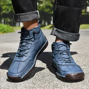Détail de bottines en cuir bleu faites main avec semelles en caoutchouc et surpiqûres blanches