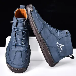 Détail de bottines en daim bleu marine avec coutures main et semelle en caoutchouc
