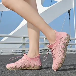 Pink low-top walking shoe featuring wavy leather stitching and a durable rubber saw-tooth sole