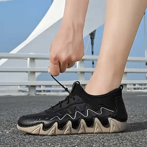 Outdoor view of black athletic shoes featuring tan sawtooth soles and bungee lace system