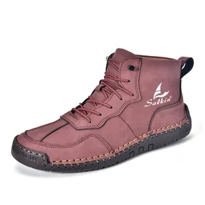 Détail de bottines en cuir marron rouge avec logo blanc et coutures artisanales robustes