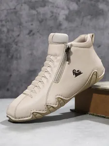 Detail von cremefarbenem Lederstiefel mit seitlichem Reißverschluss und Sägezahnsohle