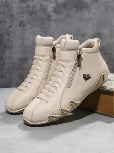 Detail von beigen Leder-High-Top-Schuhen mit seitlichem Reißverschluss und Gummisohle