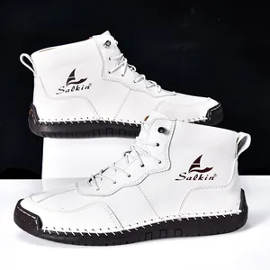 Détail de bottines en cuir blanc à tige haute avec semelle en caoutchouc marron et coutures
