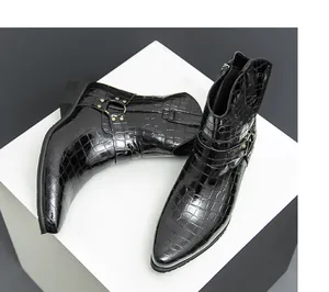 Close-up of black crocodile embossed leather boot with metal ring and rivet detail