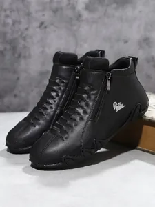 Detailaufnahme schwarzer High-Top-Lederschuhe mit Reißverschluss und silbernem Logo
