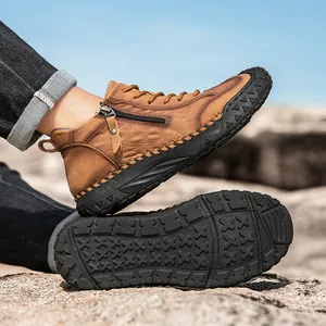 Detail view of brown leather hiking boots with side zipper and rugged non-slip rubber soles