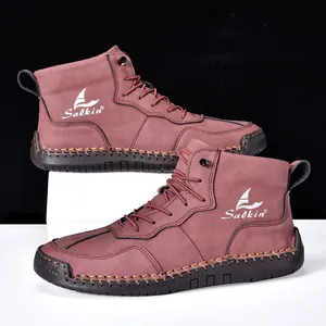 Détail de bottines en daim marron rouge avec semelles en caoutchouc et coutures à la main