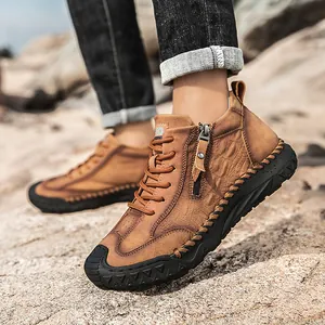 Detail of brown mid-top hiking boots with side zipper, leather texture and rugged rubber sole