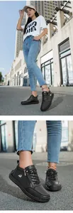 Λεπτομέρεια από μαύρα δερμάτινα sneakers με φερμουάρ και κεντημένο σχέδιο πουλιού