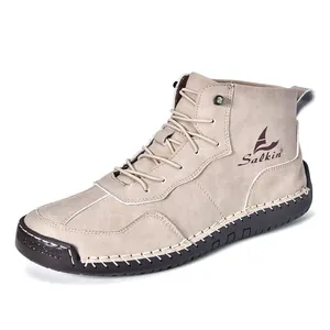 Détail de bottines en daim avec logo Salkin et surpiqûres blanches sur semelle en caoutchouc