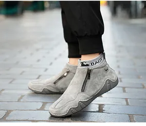 Detail von grauen Wildlederschuhen mit seitlichem Reißverschluss und elastischem Sockenrand