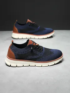 Macro detail of breathable navy flyknit mesh and leather heel stitching on men's shoe