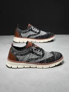 Detail of breathable knit texture and brown faux leather trim on British style sneakers
