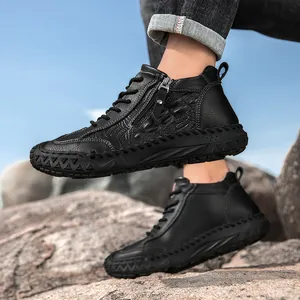 Detail of men's high-top black leather boots with side zipper and crocodile texture