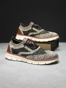 Macro detail of breathable knitted mesh and brown leather patches on men sneakers