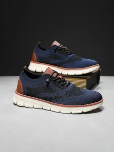 Close-up of knit brogue sneakers with navy texture and brown leather accents