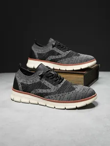 Detail of grey and black flyknit upper with brogue texture and white athletic sole