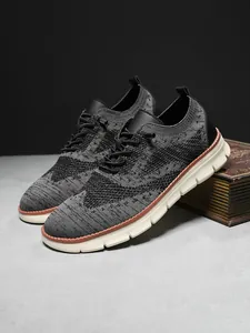 Detail of grey knitted mesh upper with brogue texture on business casual sneaker