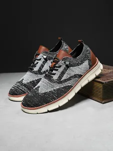 Close-up of men's knit sneakers with brown leather accents on a vintage book