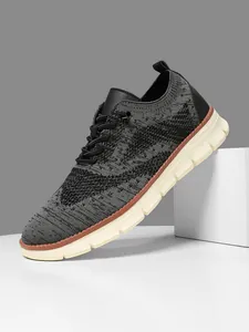 Macro shot of breathable grey knit texture and cushioned white EVA sole on men's sneakers