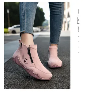Close-up of pink suede ankle boots with side zipper and numeric stitching detail