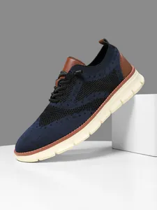 Close-up of breathable navy flyknit mesh and brown leather details on men's oxford sneakers