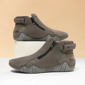 Primer plano de botines de ante gris pardo con cremallera lateral y suela de goma
